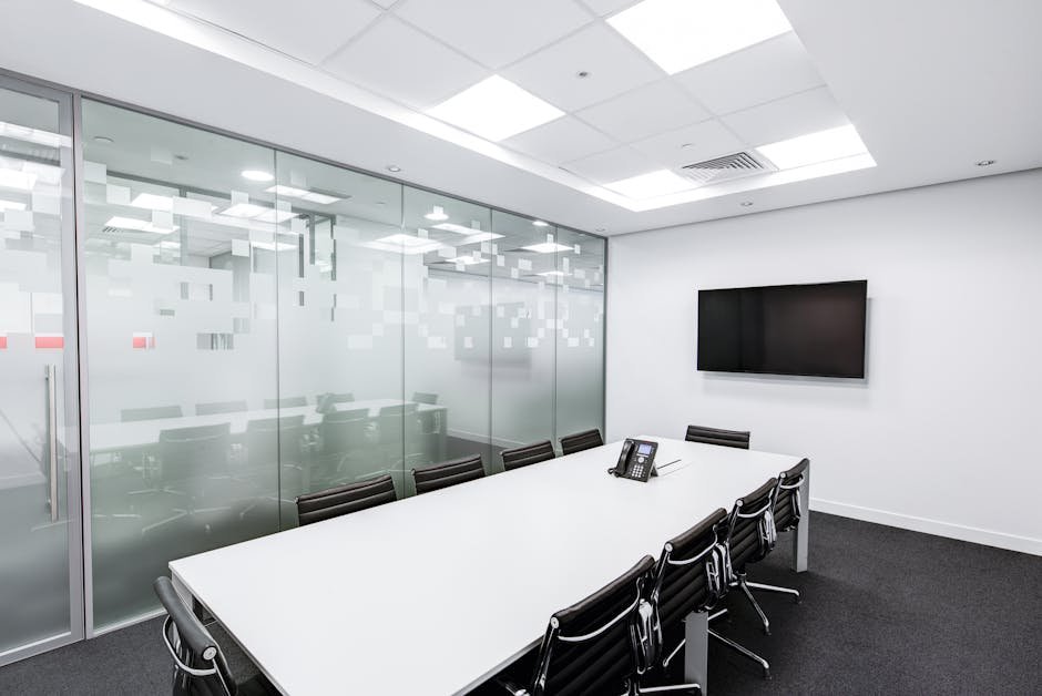 pexels-photo-260689-260689 Sleek, minimalist conference room with glass walls, long table, and office chairs.